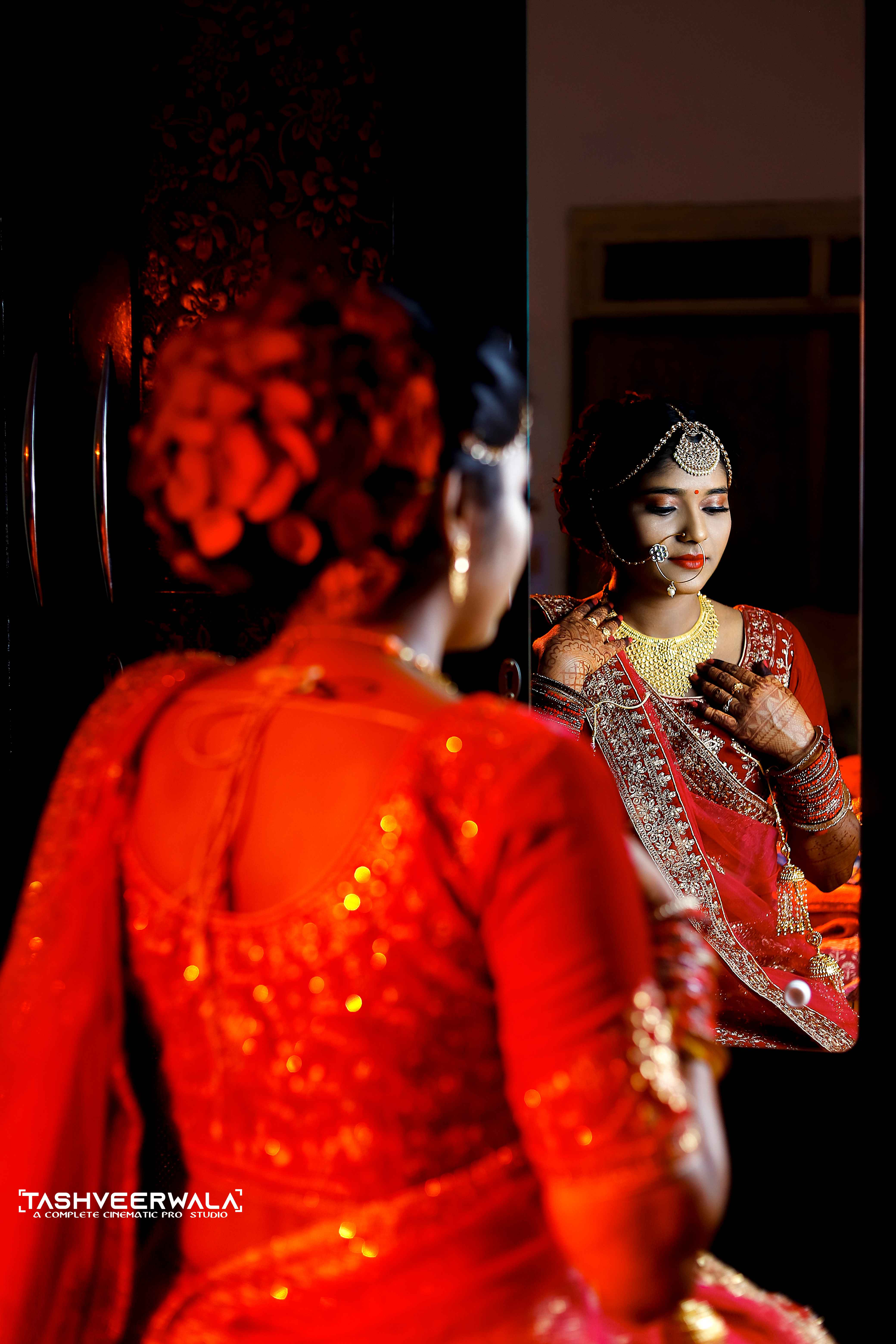 Bridal portrait with mirror reflection in traditional red attire